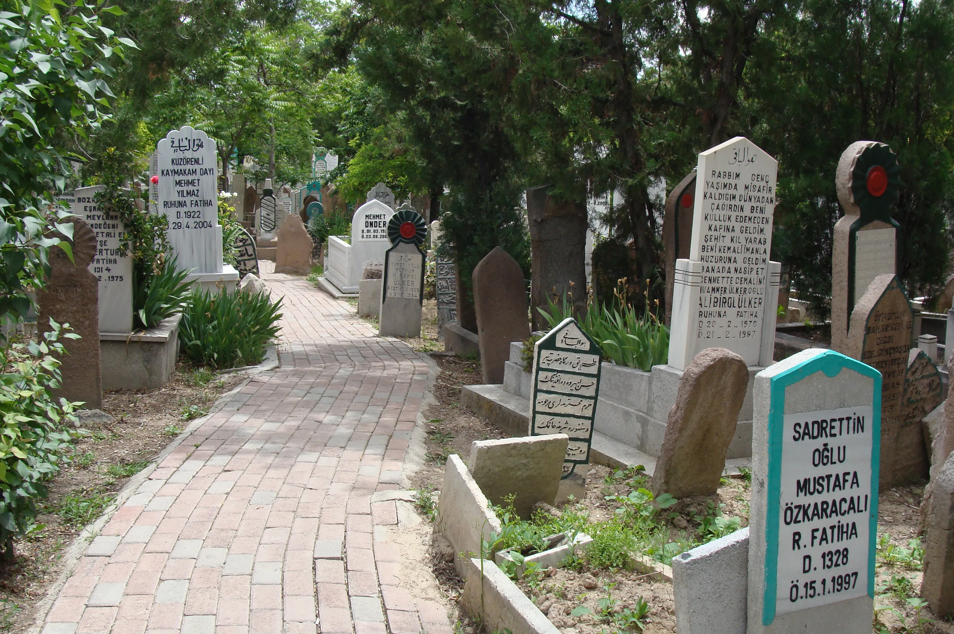 Mezarlıkta tipik modern mezarlar ve tuğla döşeli bir yol